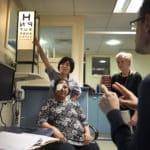 Deaf woman having her vision checked with interpreter present providing communication support